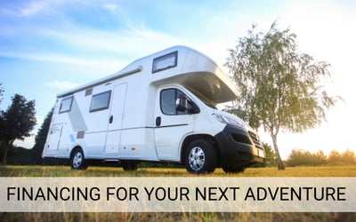White RV parked on grass under a blue sky with text overlay reading ‘Financing for Your Next Adventure,’ promoting recreational vehicle, ATV, and boat loans in Tulsa.