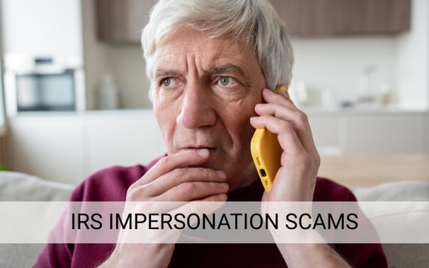 Man looking worried while talking on phone about IRS impersonation scam